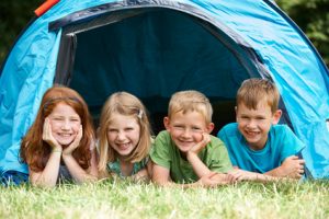 4 children smiling under a tent
